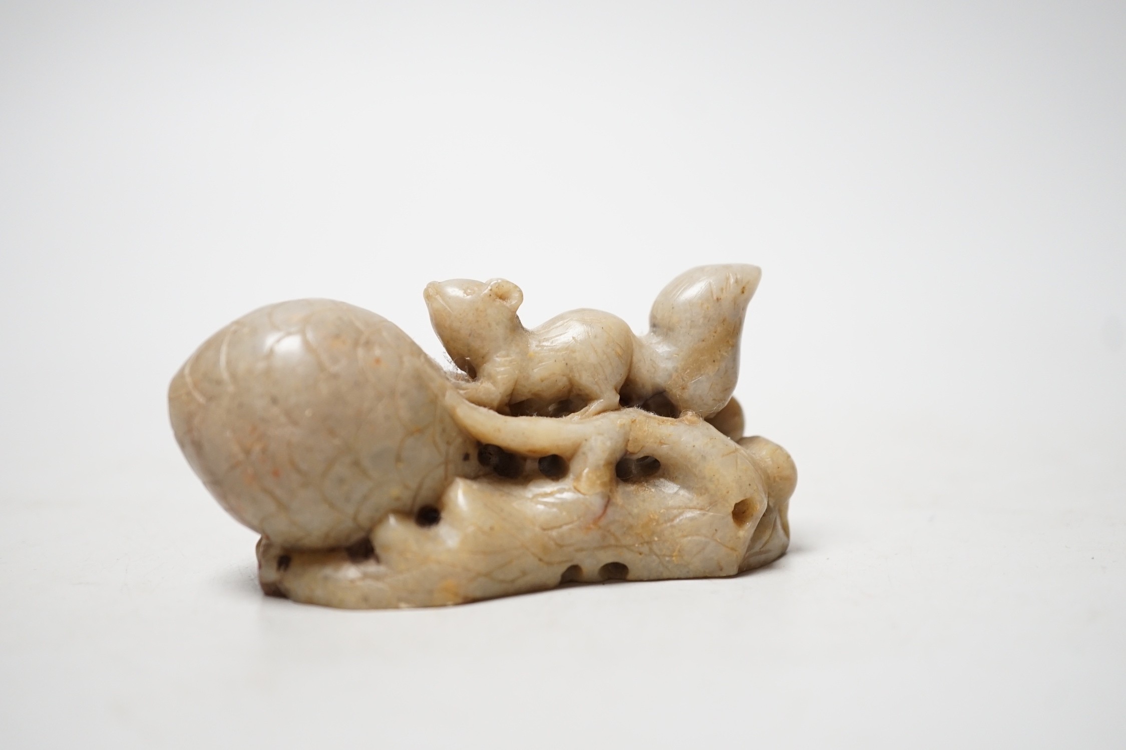 A Chinese carved soapstone carving of a squirrel and pine cone 8.5cm